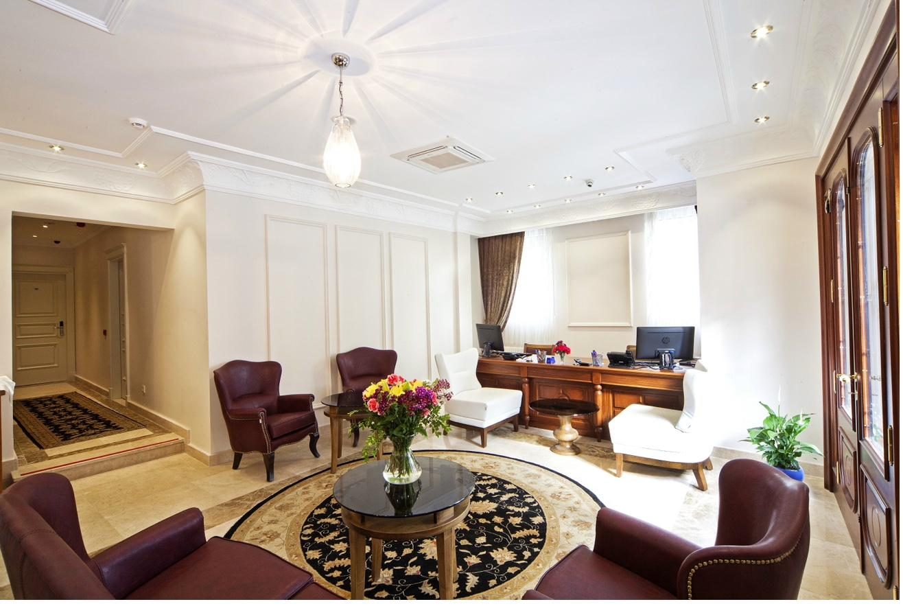 Spacious lobby with ornate ceiling, chandelier and seating area