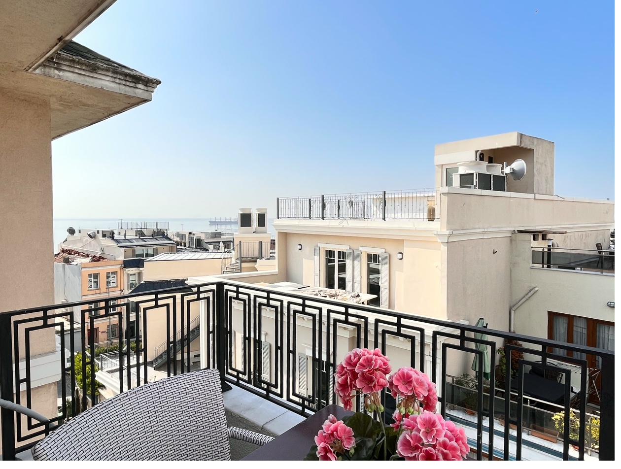 Private balcony with sea view, table and wicker chairs