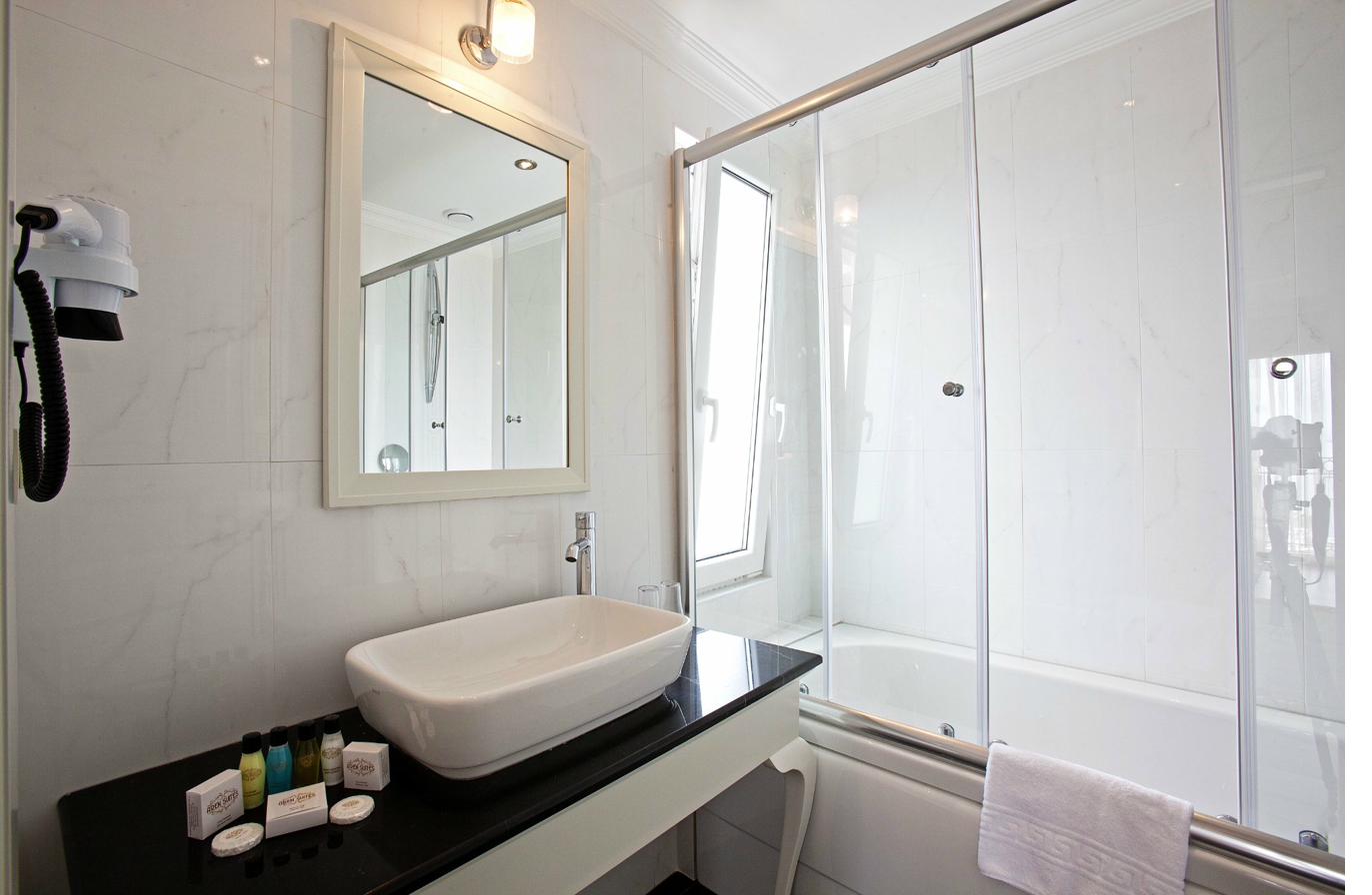 Superior Quadruple Room bathroom with glass shower and vessel sink