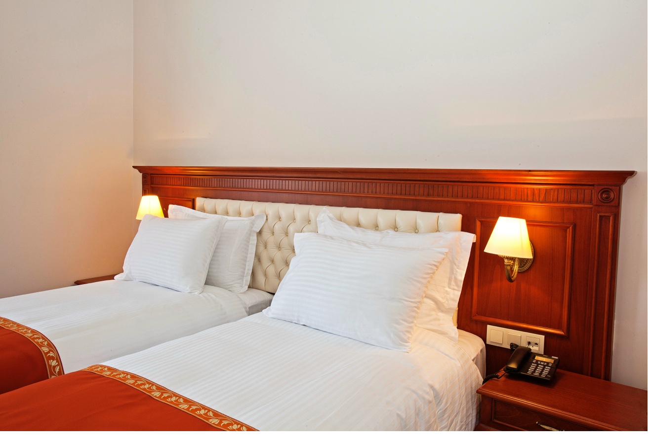 Standard Double Room bed detail with warm bedside lighting